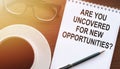 Are you uncovered for new opportunities? Motivational text on notepad with glasses and cup of coffee and glasses Royalty Free Stock Photo