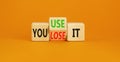 You use or lose it symbol. Concept word You use or lose it on wooden cubes. Beautiful orange table orange background. Business and Royalty Free Stock Photo
