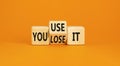 You use or lose it symbol. Concept word You use or lose it on wooden cubes. Beautiful orange table orange background. Business and Royalty Free Stock Photo