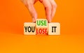 You use or lose it symbol. Concept word You use or lose it on wooden cubes. Beautiful orange table orange background. Businessman Royalty Free Stock Photo