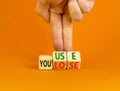 You use or lose it symbol. Concept words You use and You lose on wooden cubes. Businessman hand. Beautiful orange table orange Royalty Free Stock Photo