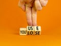 You use or lose it symbol. Concept words You use and You lose on wooden cubes. Businessman hand. Beautiful orange table orange Royalty Free Stock Photo