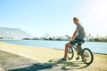 You wanna come for a ride. Full length portrait of a young boy riding his bike alongside a lagoon.