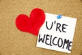 You Are wellcome sign written on sticky note pinned on pinboard with rd heart Royalty Free Stock Photo