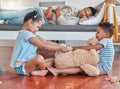 While you were sleeping. two siblings fighting over a teddy on the floor while their dad sleeps on the couch at home.