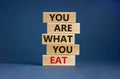 You are what you eat symbol. Stack of wooden blocks. Words `You are what you eat`. Beautiful grey background. Healthy eating