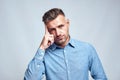 You Are What You Think. Portrait of young and smart bearded man in casual wear touching his head and looking at camera