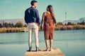 You are the whole of my heart. Rearview shot of a young couple holding hands while standing together on a pier at a Royalty Free Stock Photo