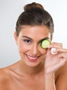 You wont catch me with bags under my eyes. Portrait of a gorgeous young woman holding a slice of cucumber over her eye. Royalty Free Stock Photo