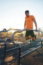 You wont know what you can achieve until you try. a young man working out at the outdoor gym at the park.