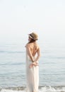 Youg calm dreaming woman standing alone near sea