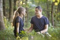 Youg couple, man and a woman sitting together outdoors enjoying nature