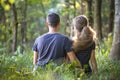 Youg couple, man and a woman sitting together outdoors enjoying nature