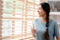 Youn beautiful asian woman drinking water while standing by window in kitchen background, peolpe and healthy lifestyles