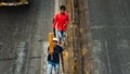 Youn guys cross the street in bombay with a cricket beat