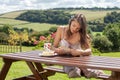 Yound attractive woman, reading a book outdoor, enjoying coffee