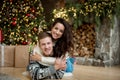 Yound couple beautiful wife hugging her beloved husband in room decorated for celebrating new year looking happy festive