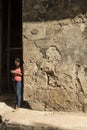 Yound woman standing by worn wall Havana