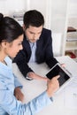 Young academics sitting at desk looking at presentation on table