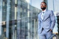 Young accomplished african american CEO business founder entrepreneur, stylish suit and glasses standing confidently at workplace