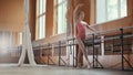 Young acrobatic girl shows the flexibility of the body at the ballet bar