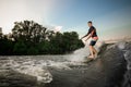 Young active brunet man riding on the wakeboard on the lake Royalty Free Stock Photo