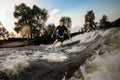 Young active brunet man riding on the wakeboard near the lakeside Royalty Free Stock Photo