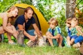 Young active family making camp fire in the woods