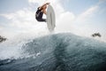 Young active man jumping up on the white wakeboard on the high b Royalty Free Stock Photo