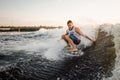 Young active man riding on the wakeboard on the lake Royalty Free Stock Photo