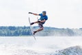 Young active man riding wakeboard on a wave from a motorboat on summer lake Royalty Free Stock Photo