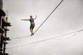 Young active man walking on the slackline rope