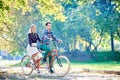 Young couple, handsome man and attractive woman on tandem bike in sunny summer park or forest. Royalty Free Stock Photo