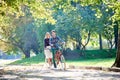 Young couple, handsome man and attractive woman on tandem bike in sunny summer park or forest. Royalty Free Stock Photo