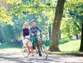 Young couple, handsome man and attractive woman on tandem bike in sunny summer park or forest. Royalty Free Stock Photo