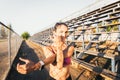 young active sport woman seen from the back stretching shoulders beside of the running track Royalty Free Stock Photo