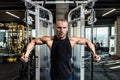 Young active strong sweaty focused fit muscular bodybuilder man chest muscles stretching workout on cable machine in the gym Royalty Free Stock Photo