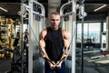 Young active strong sweaty focused fit muscular bodybuilder man chest muscles stretching workout on cable machine in the gym Royalty Free Stock Photo