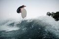 Young and active wakeboarder jumping on the blue splashing wave Royalty Free Stock Photo