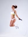 Young active woman with jump rope in studio