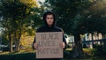 young activist in hoodie holding placard