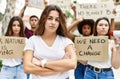 Young activist woman with arms crossed gesture standing with a group of protesters holding protest banner at the city Royalty Free Stock Photo