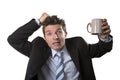 Young addict business man in suit and tie holding empty cup of coffee anxious