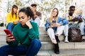 Young addicted people using smart phone outdoors. Royalty Free Stock Photo