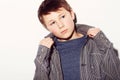 Hes got his own personal style. Young adolescent boy adjusting his shirt against a white background. Royalty Free Stock Photo