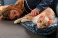 An Young Adolescent girl lying on a couch finds comfort by snuggling close to and petting her cat Royalty Free Stock Photo