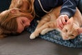 An Young Adolescent girl lying on a couch finds comfort by snuggling close to and petting her cat Royalty Free Stock Photo