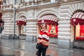 Young and adorable russian girl posing in front of Gum famous shop in Moscow on the Red Square through winter holiday