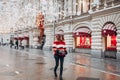 Young and adorable russian girl posing in front of Gum famous shop in Moscow on the Red Square through winter holiday