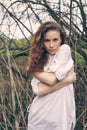 Young adorable woman with curly hair portrait near tree